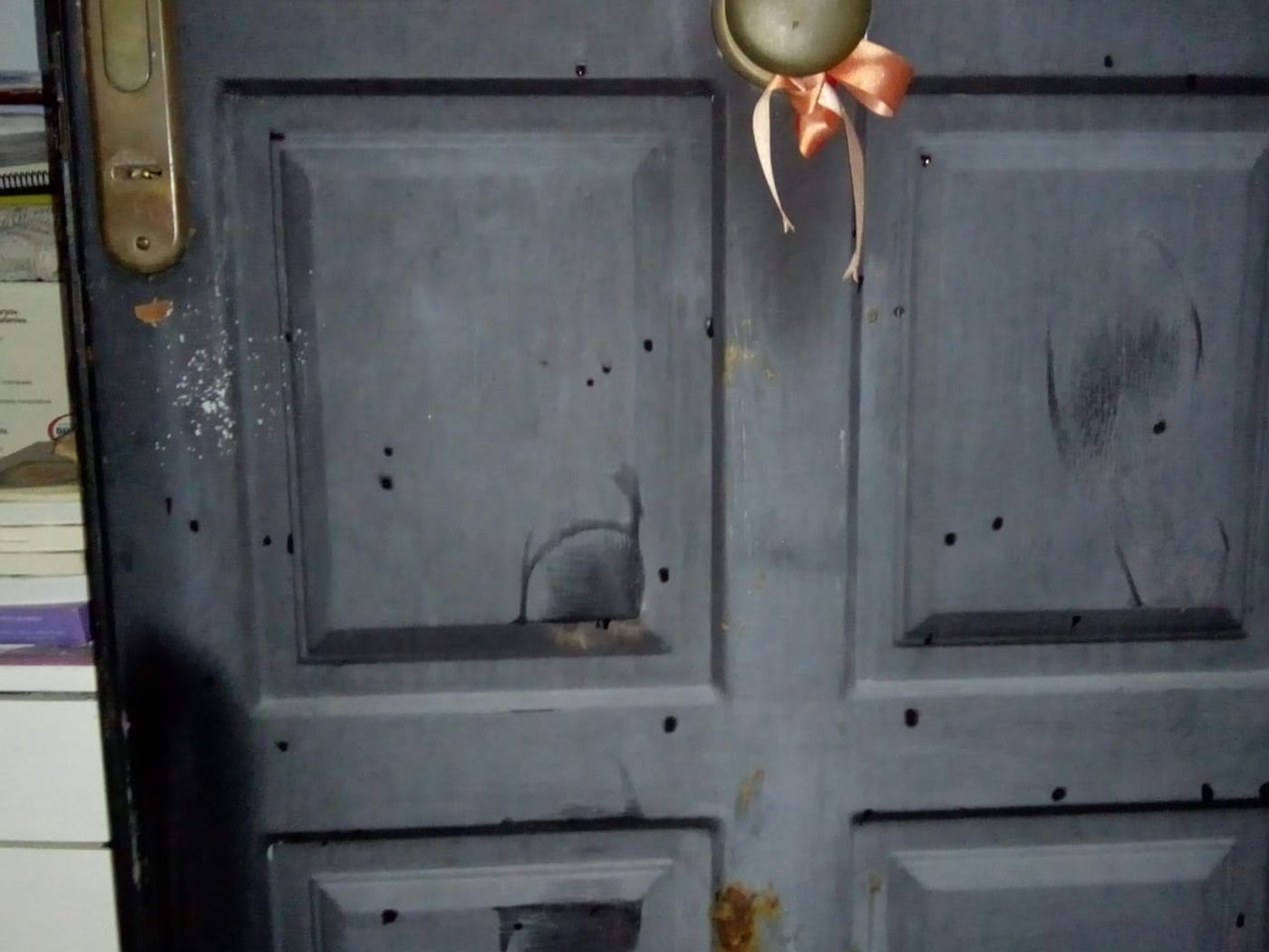 Las marcas de golpes en la puerta del frente hechas por el hermano del propietario.