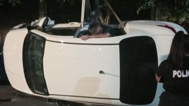 un uber con dos pasajeros a bordo choco contra un auto estacionado y volco en la plata