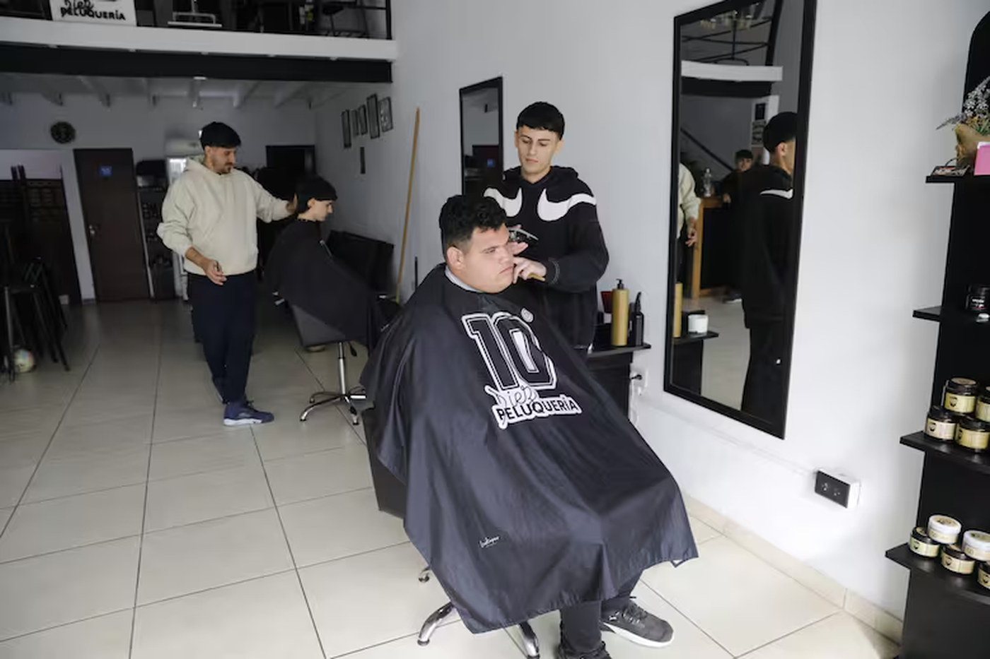La peluquería de Franco Agostinelli (de buzo claro), quien fuera peluquero de Diego Maradona