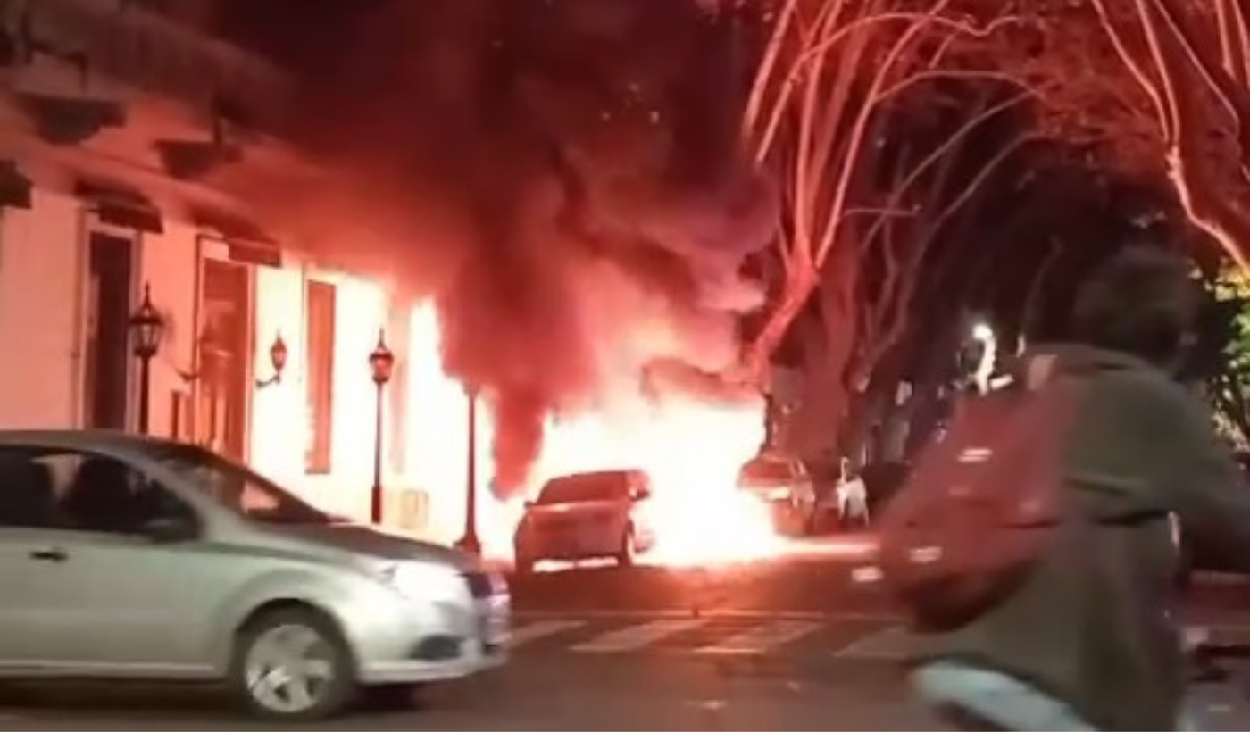 El auto en llamas despu&eacute;s de que fueran quemados los contenedores en 56 entre 6 y 7, pleno centro de La Plata
