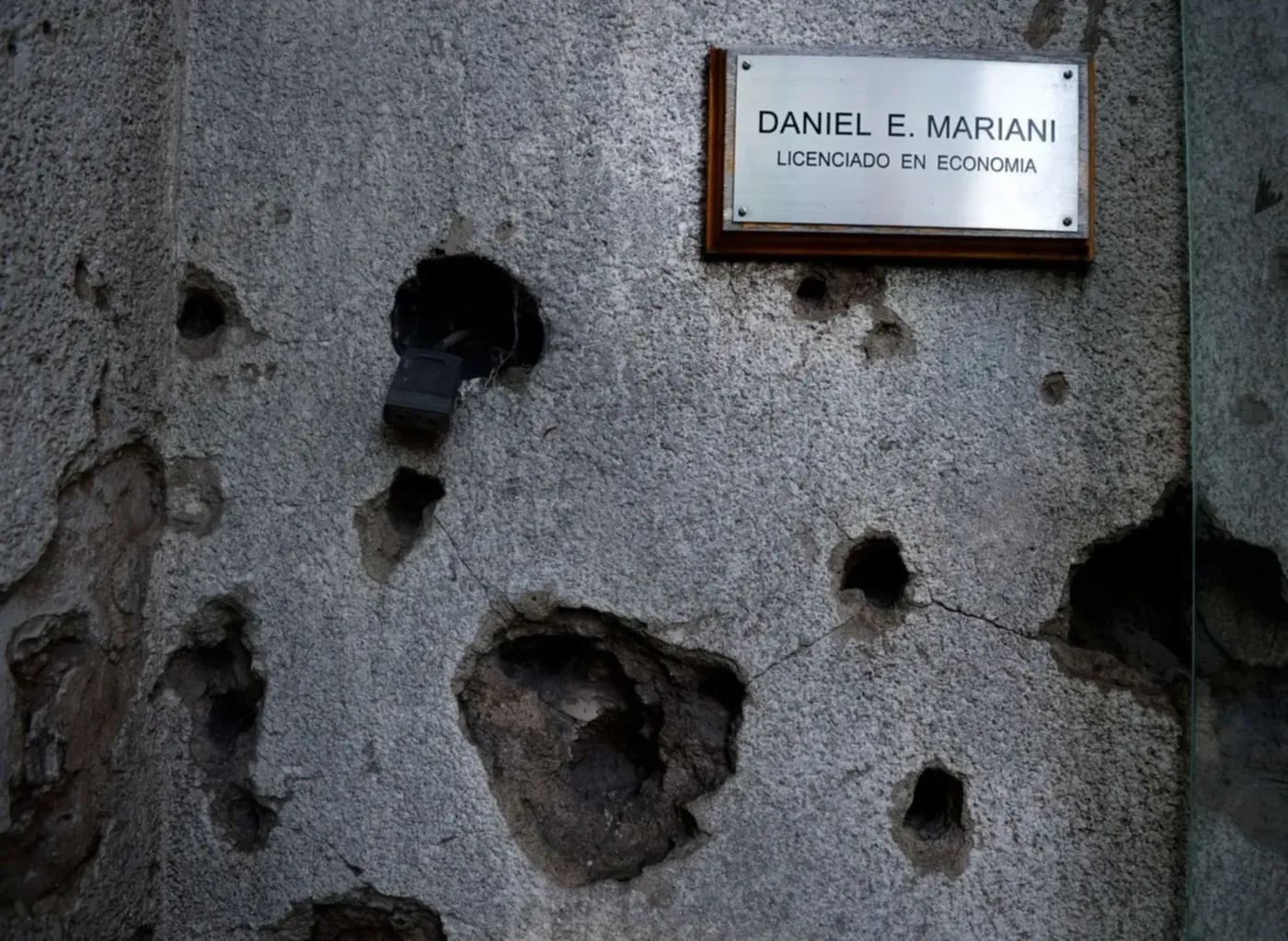 La placa de bronce de Daniel Mariani, en la puerta de la casa de calle 30, junto a los vestigios del tiroteo 
