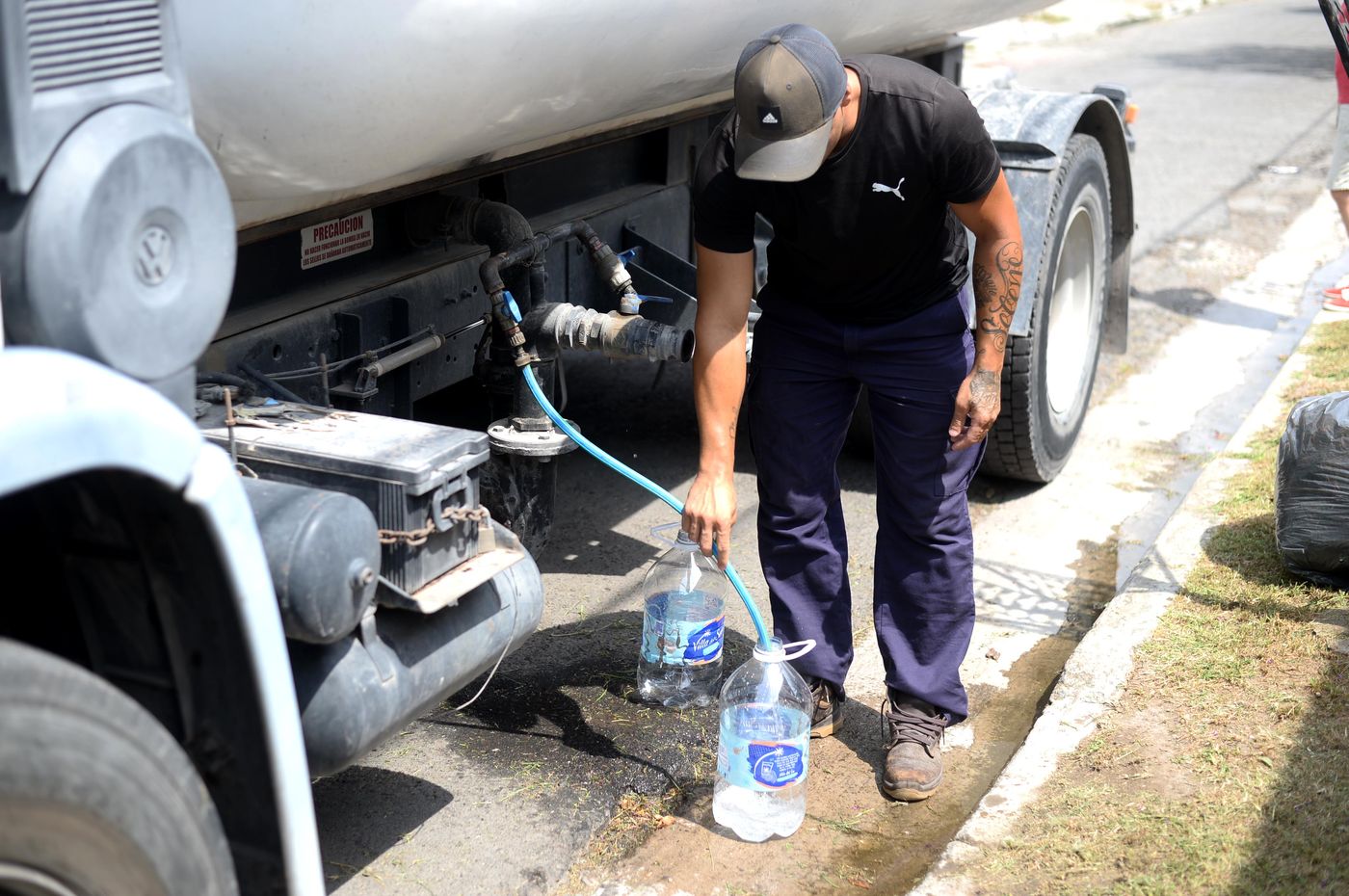 Un trabajador de ABSA llenando con agua potable los bidones que los vecinos acercan. Un trabajador de ABSA llenando con agua potable los bidones que los vecinos acercan.
