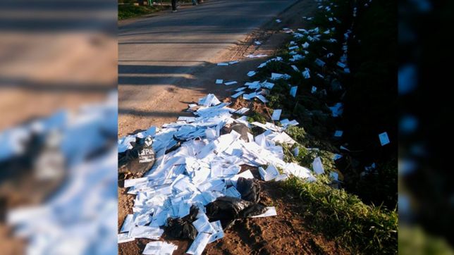 la increible imagen de un basural en plena calle formado por boletas de edelap