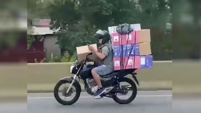 video: un hombre iba en moto con mas de 7 cajas y el celular en la mano por la autopista