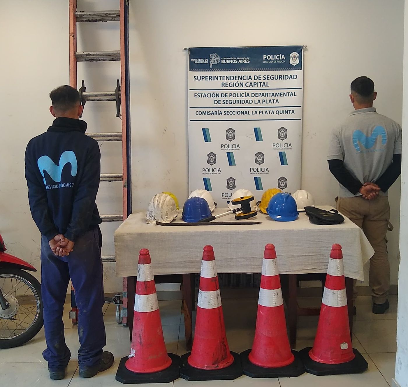 Dos de los detenidos en La Plata, con uniformes de Movistar y el material de trabajo que utilizaban.