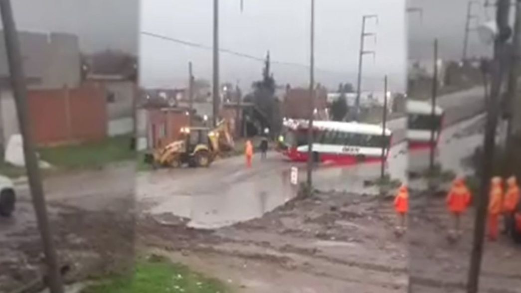 Un micro se estancó en el medio de la calle en pleno temporal y lo sacaron con una grúa