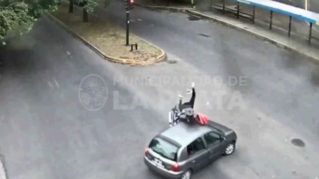 video: un motociclista choco con un auto y termino sentado arriba del capot