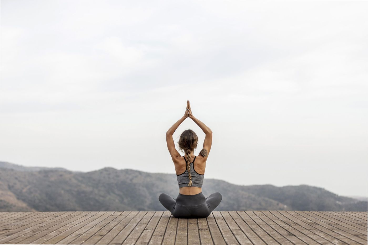 vista-posterior-mujer-haciendo-yoga-al-aire-libre-1-scaled