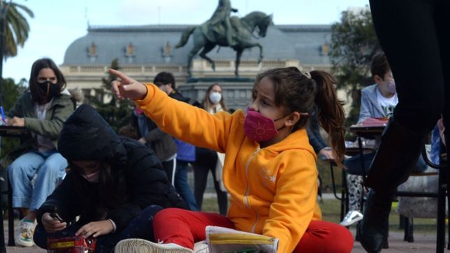 con bancos, hojas y lapices, hicieron una clase publica por la vuelta de la presencialidad