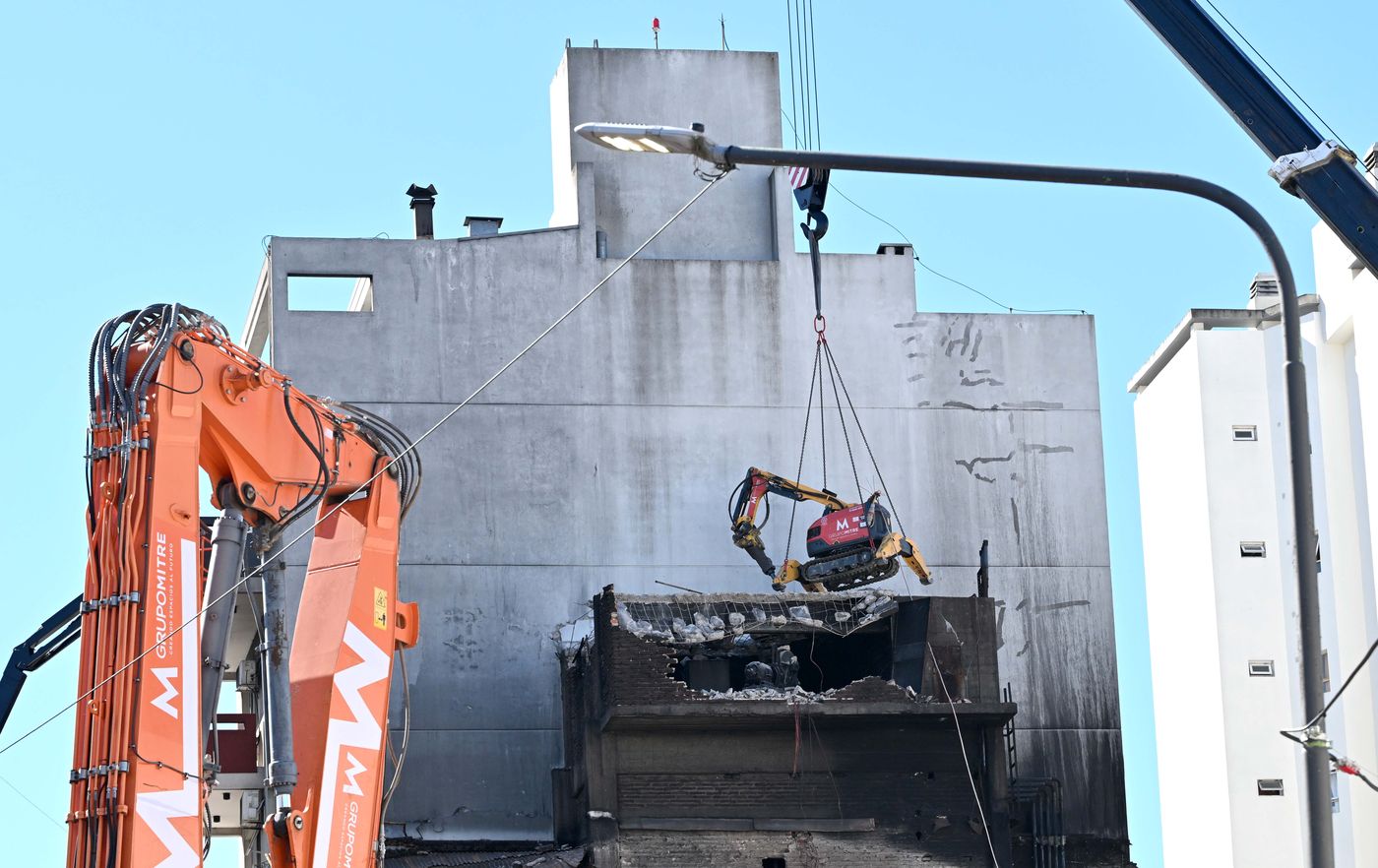 Una grúa coloca el robot telecomandado de demolición Brokk en la estructura a demoler
