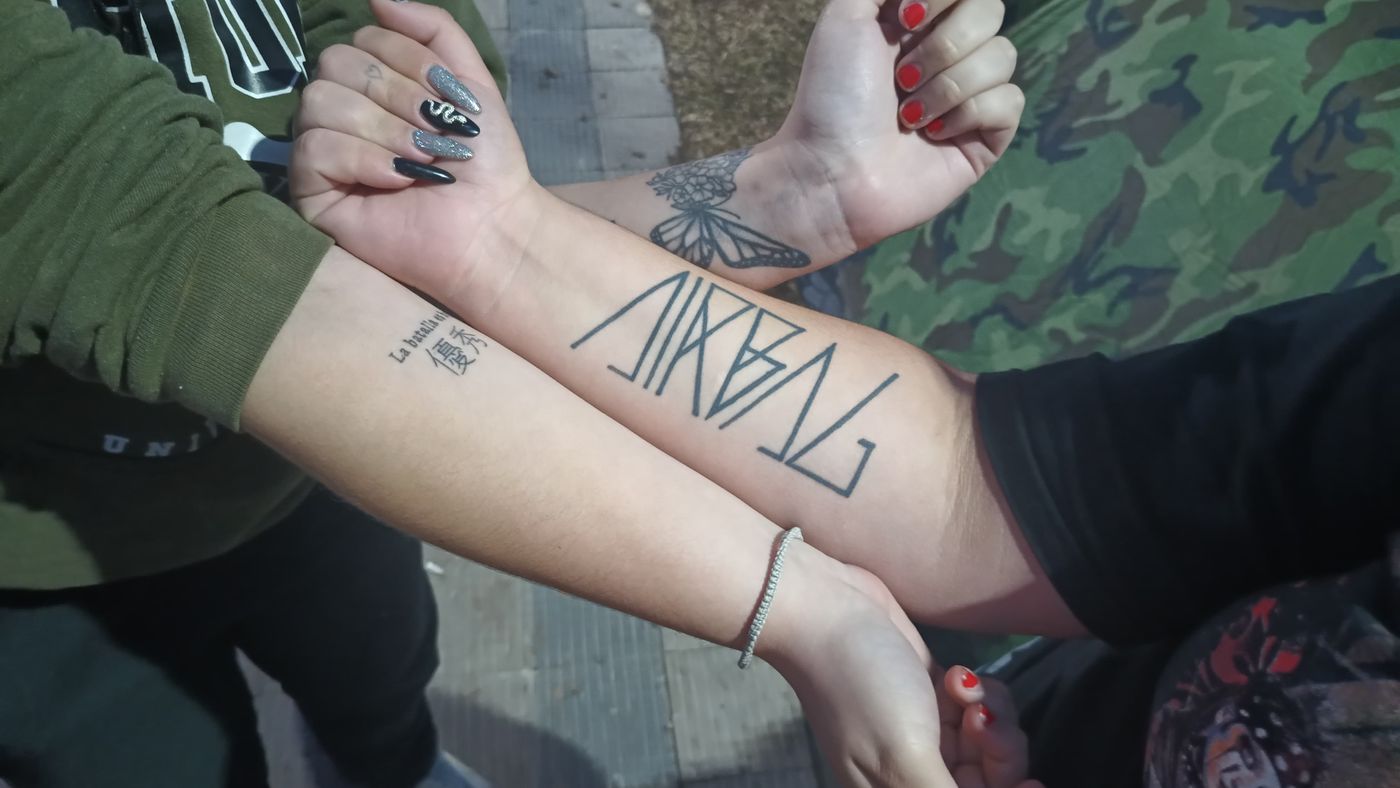 Los tatuajes de las chicas que esperan la presentación de Airbag en La Plata.