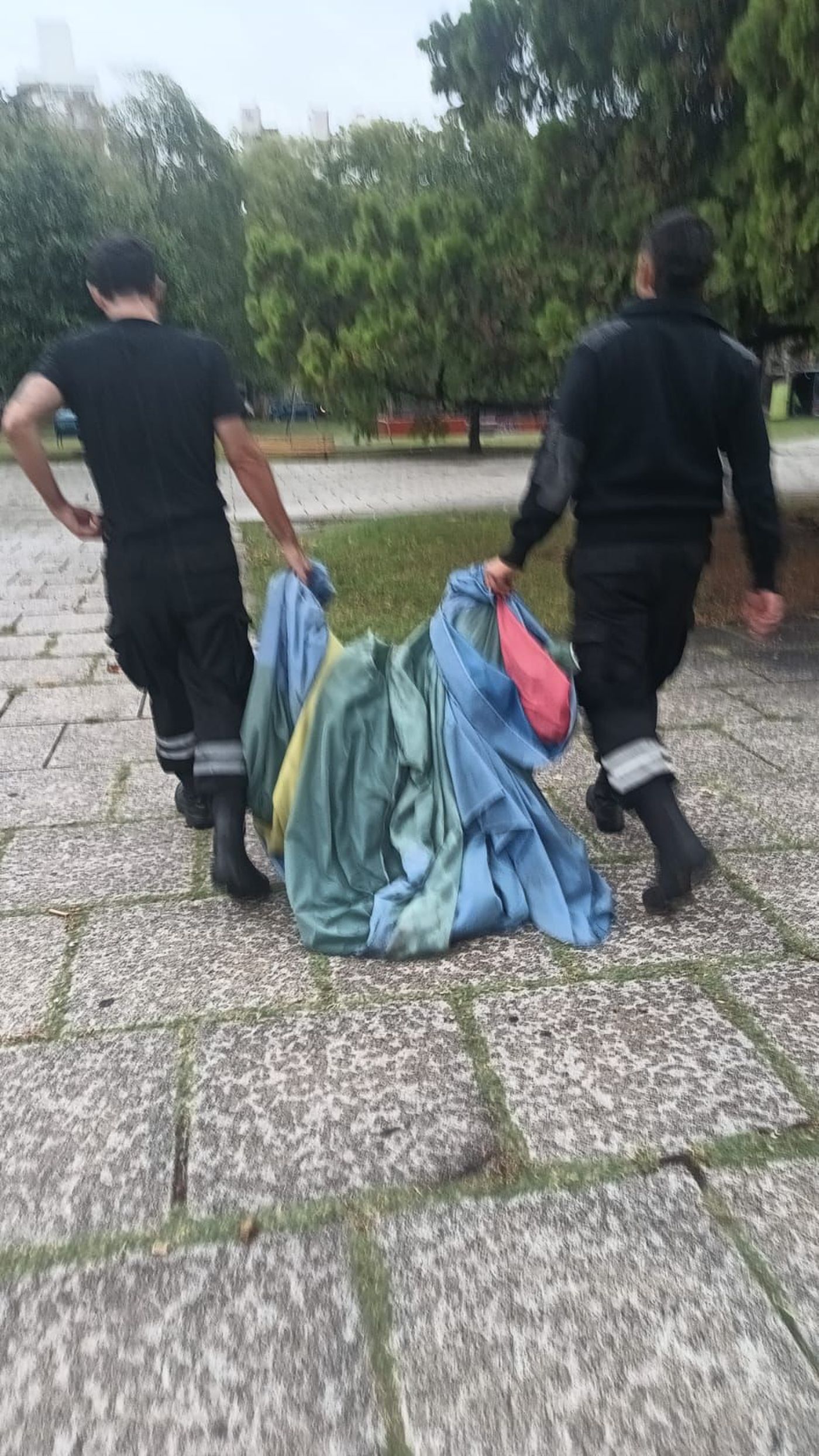 Trabajadores de Seguridad de la Municipalidad recogieron la bandera bonaerense que se cayó del mástil de plaza Moreno.