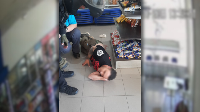 el instante en que uno de los heridos por el tiroteo entre hells angels y tehuelches se desploma en una estacion de servicios