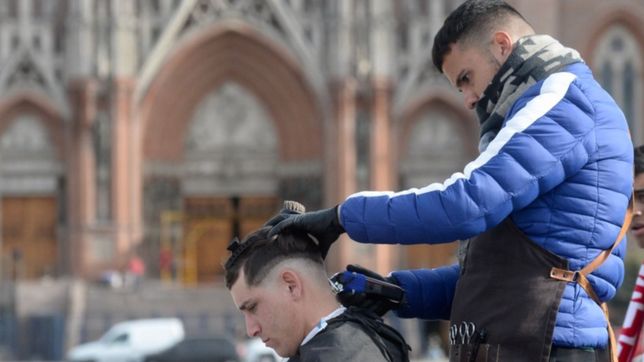 se quedo sin trabajo y corta el pelo en medio de plaza moreno para poder vivir